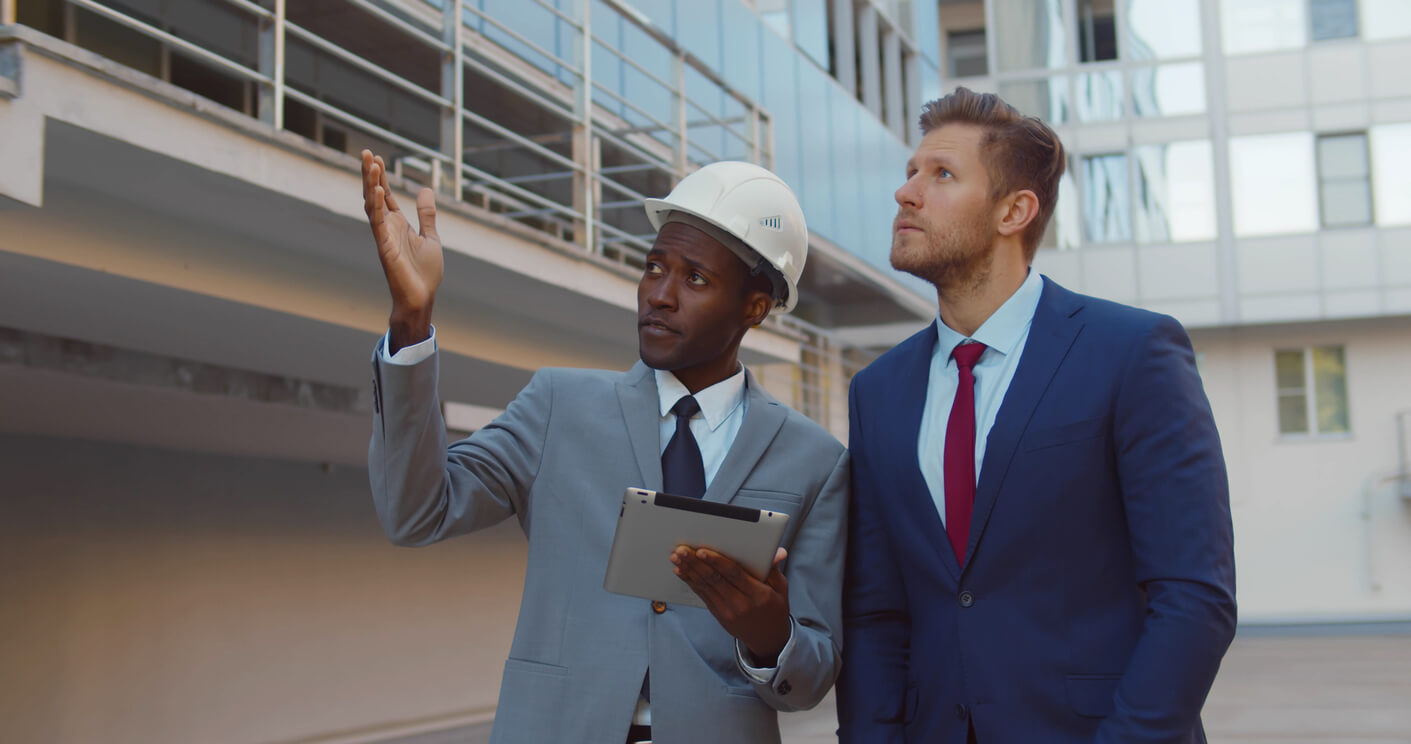 Photo of inspector and man looking at commercial building for Commercial Insurance Inspections